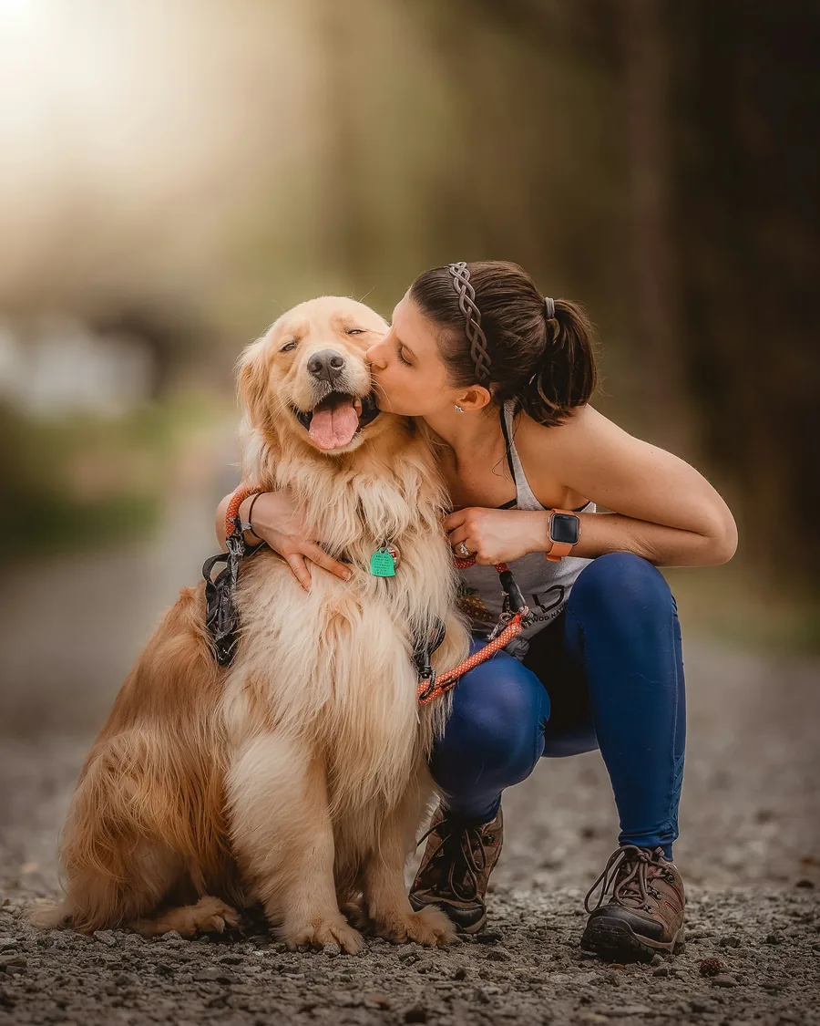 Woman hugging her golden retriever, background replaced with a warm gradient, before